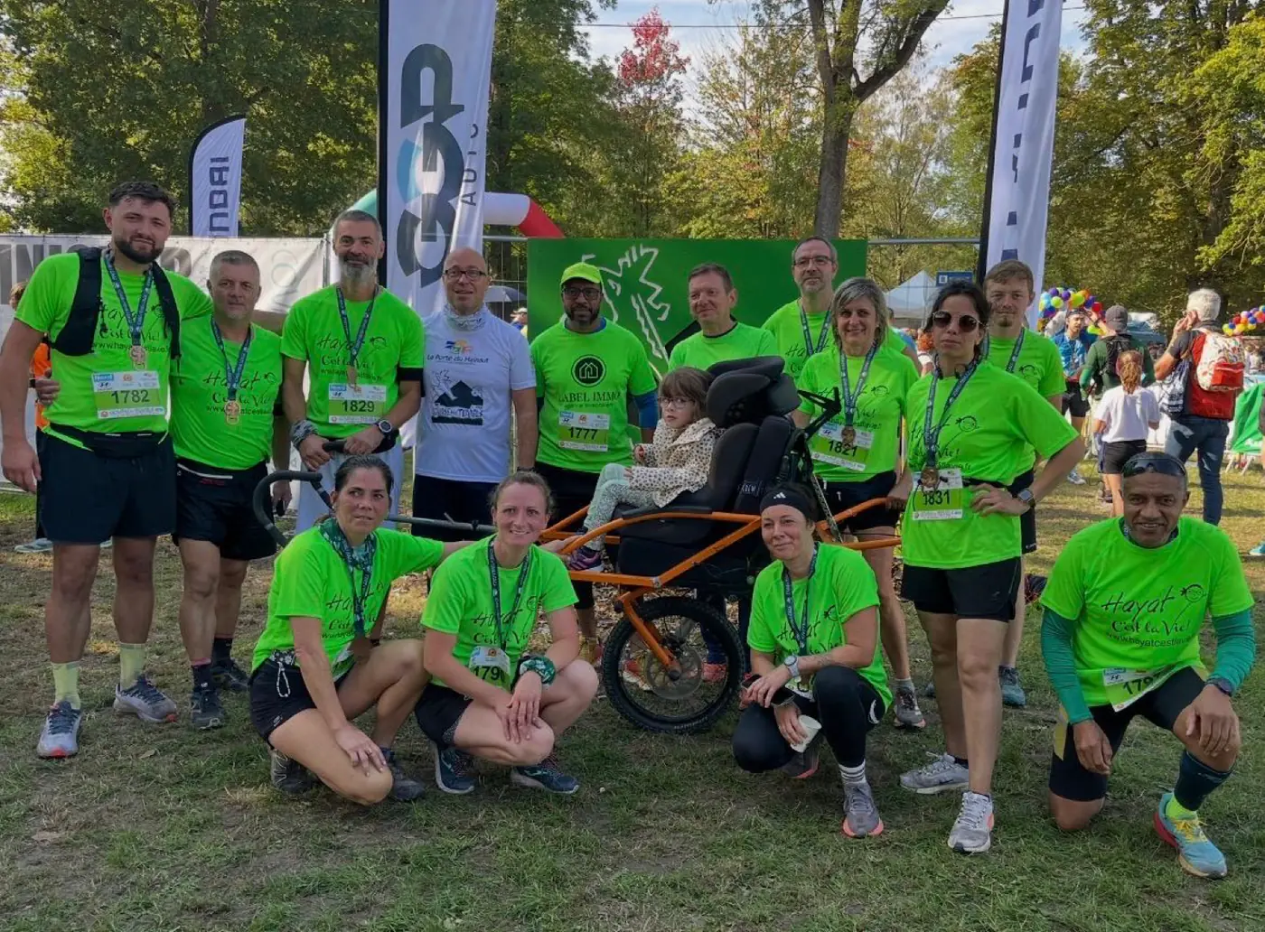 L'équipe de l'association Hayat c'est la vie en t-shirts verts autour d'une joëlette