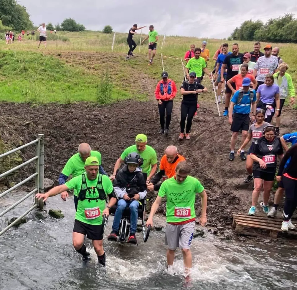 Traversée d'un gué en joëlette pendant un trail solidaire